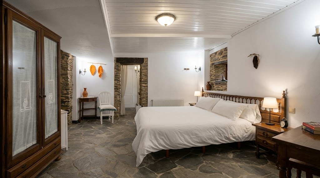 El Buxo: cama doble, armario de madera y suelo de piedra.